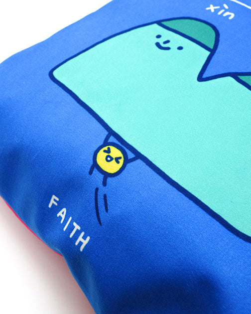 Up-close of 'faith' cushion cover in blue with 'mustard seed can move mountains' illustration.