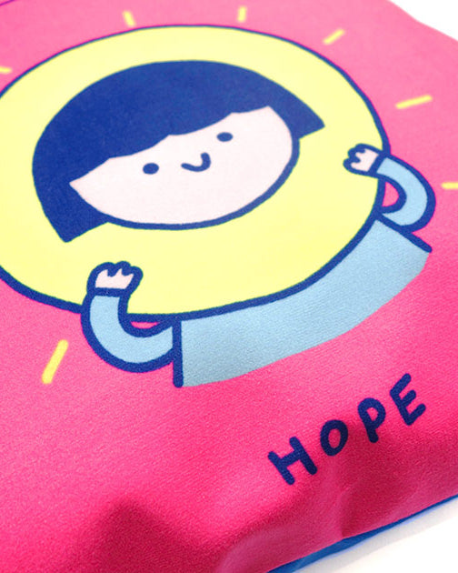 Up-close of dream chaser 'hope' cushion cover in pink with cute girl illustration.